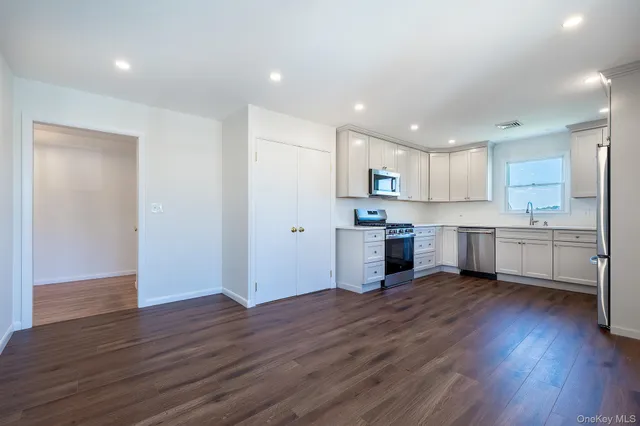 a view of a kitchen with wooden floor and electronic appliances