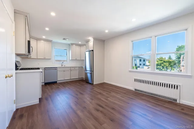 a view of a kitchen with wooden floor and a window