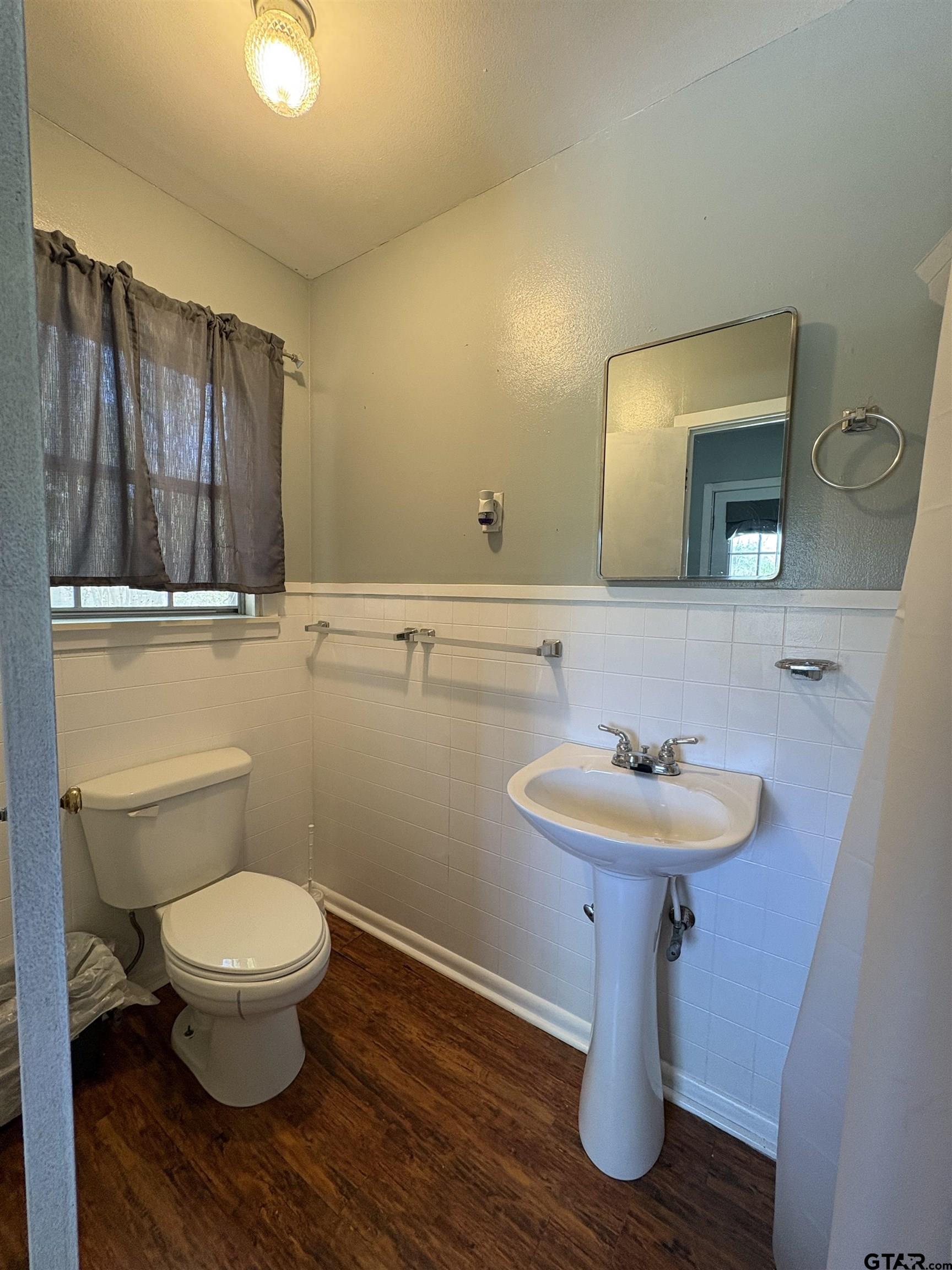 409 East Main Street Omaha, TX 75571 - Photo 14 of 15 a bathroom with a toilet a sink and mirror