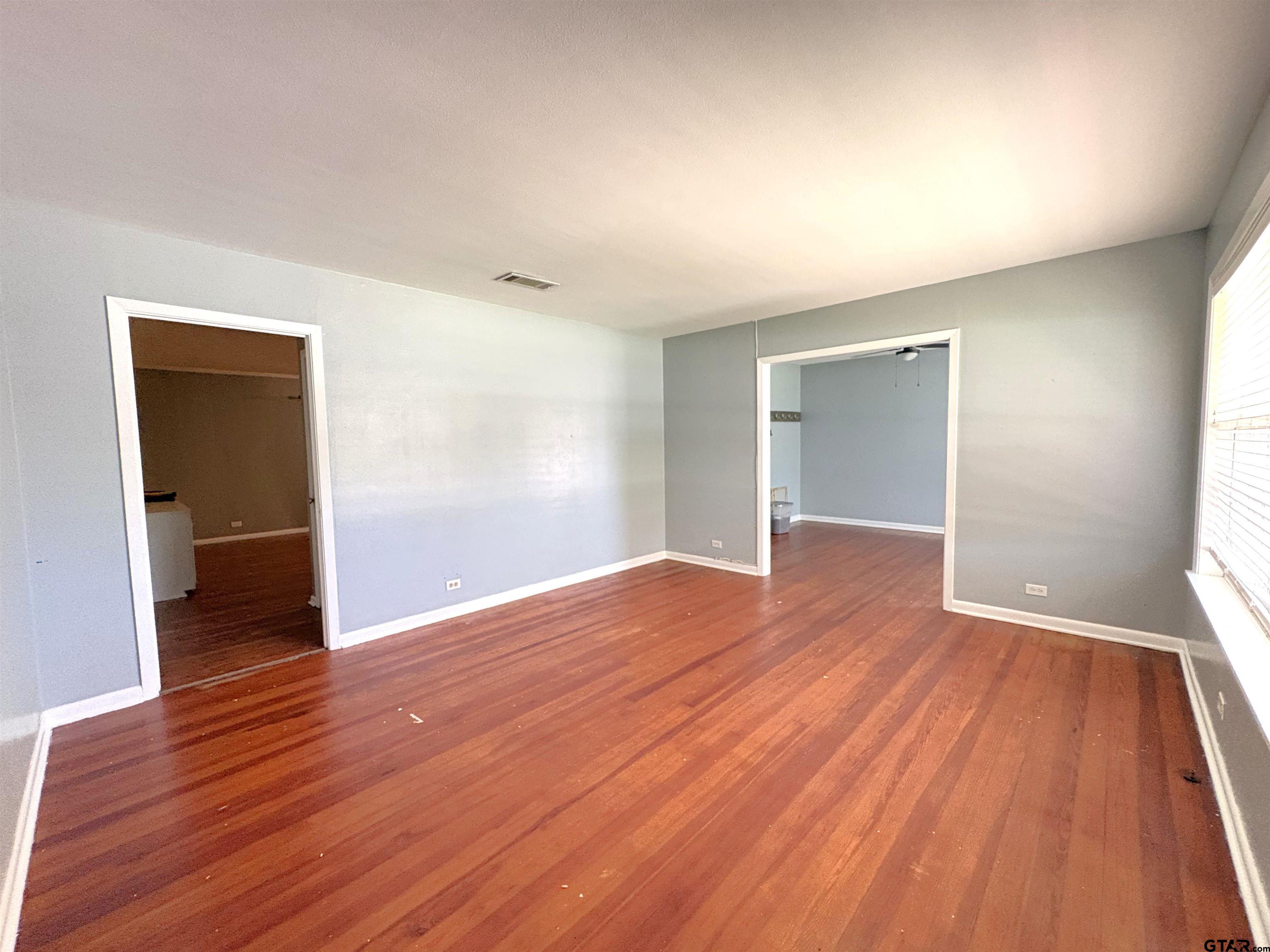 409 East Main Street Omaha, TX 75571 - Photo 6 of 15 wooden floor in an empty room with a window