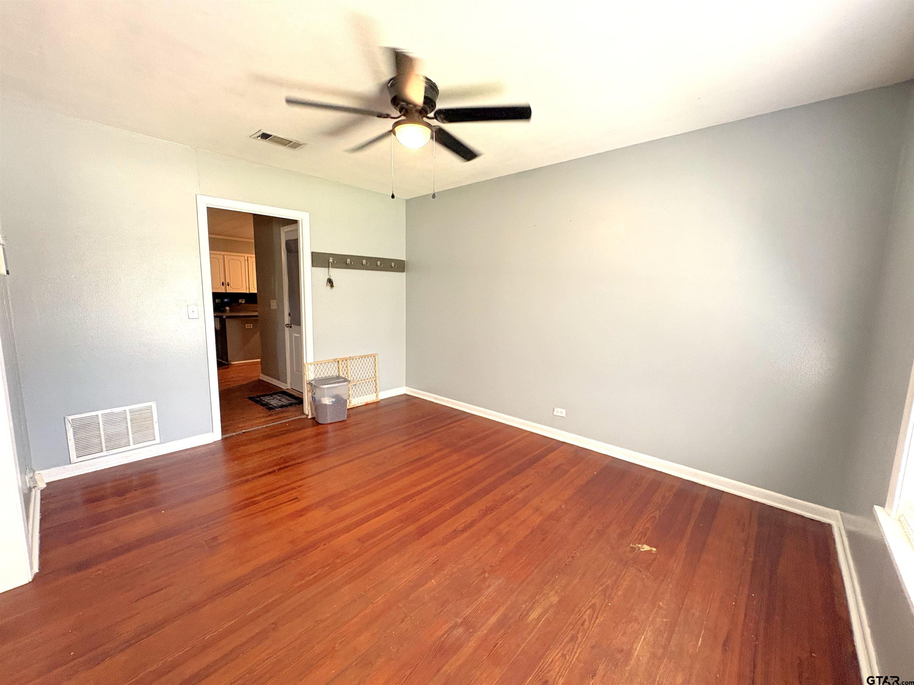 409 East Main Street Omaha, TX 75571 - Photo 7 of 15 a view of room with wooden floor ceiling fan