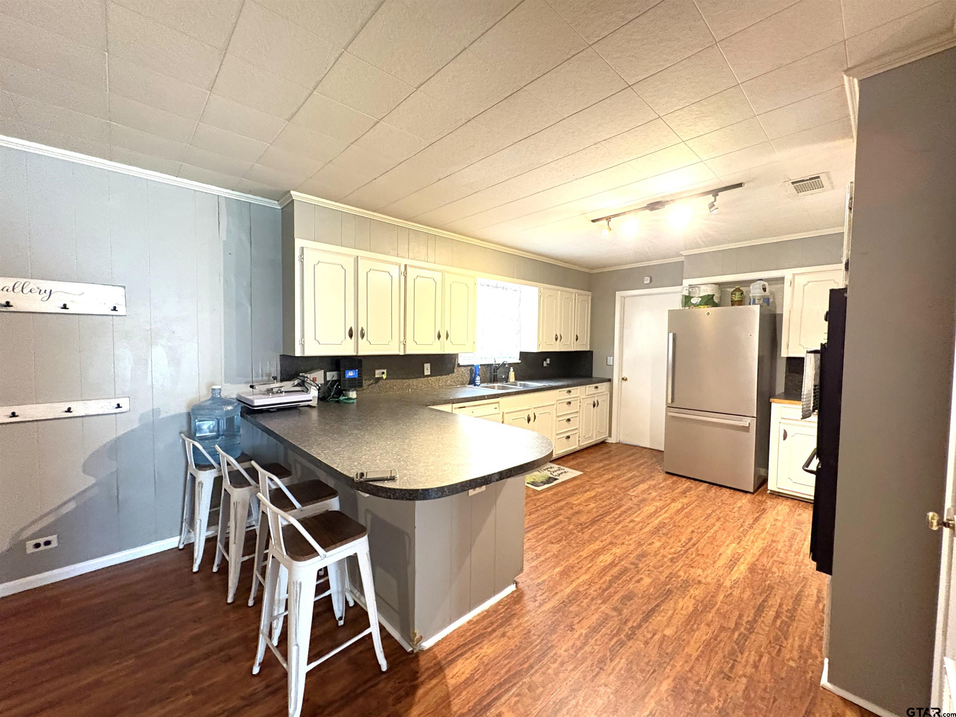 409 East Main Street Omaha, TX 75571 - Photo 8 of 15 a kitchen with kitchen island a sink table and chairs