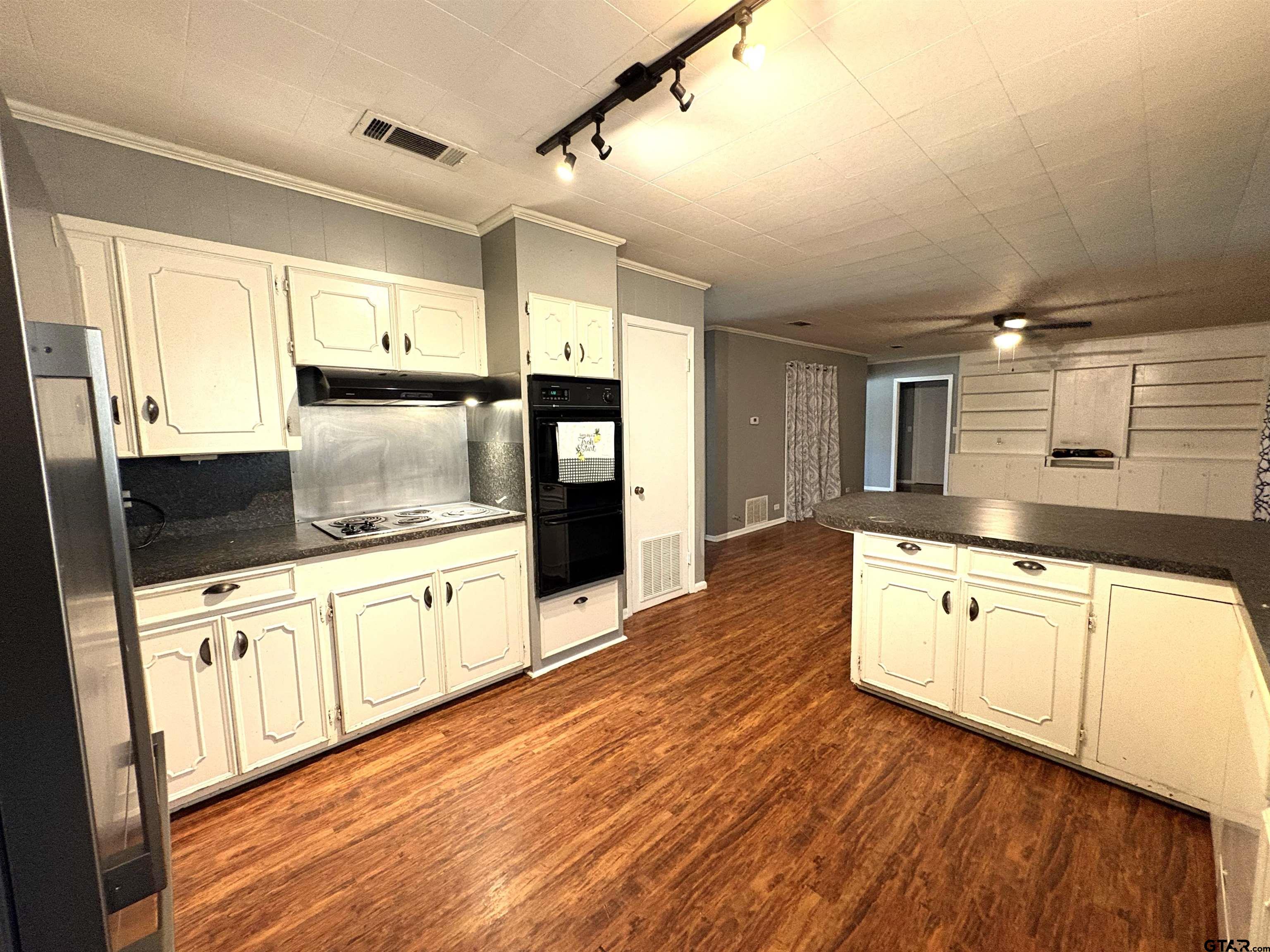 409 East Main Street Omaha, TX 75571 - Photo 9 of 15 a kitchen with stainless steel appliances granite countertop a sink a stove and wooden floors