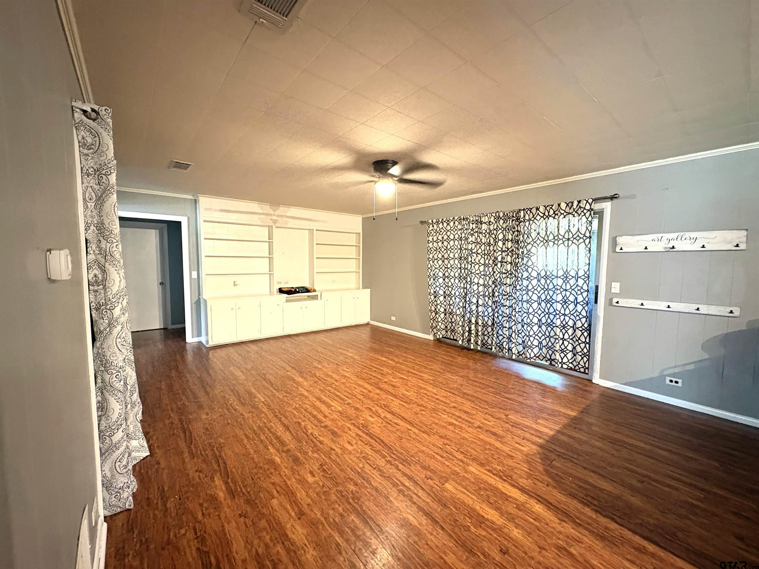 409 East Main Street Omaha, TX 75571 - Photo 10 of 15 a view of an empty room with wooden floor and a window