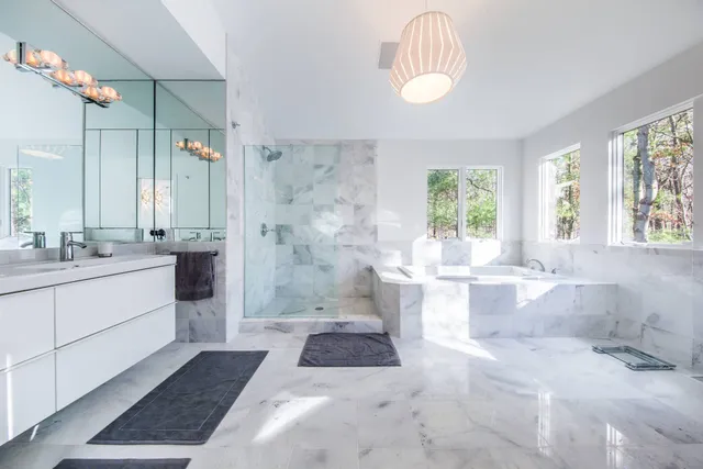 a bathroom with a tub sink and mirror