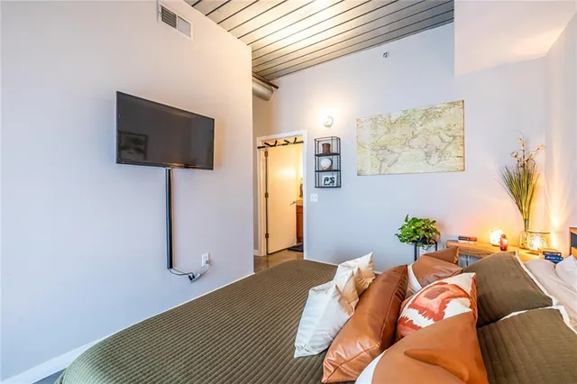 a bedroom with a bed and flat screen tv