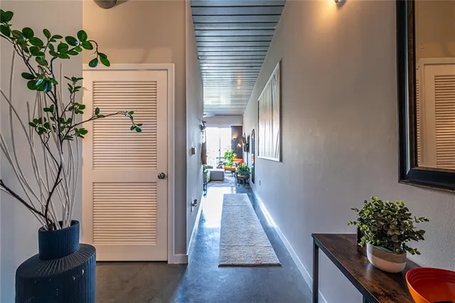 a view of a hallway with furniture and a potted plant