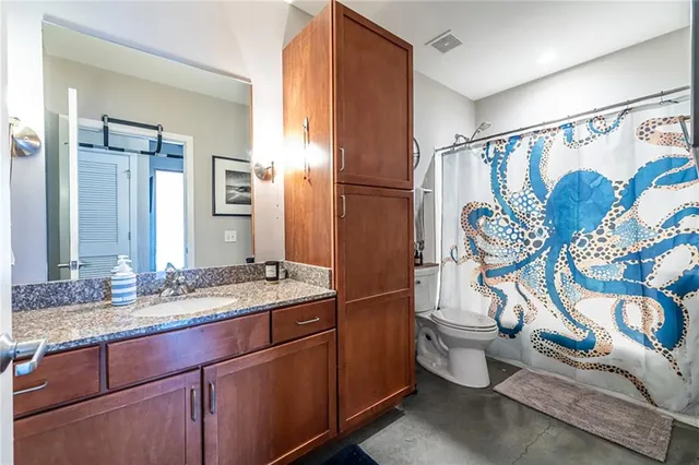 a bathroom with a granite countertop sink toilet and shower