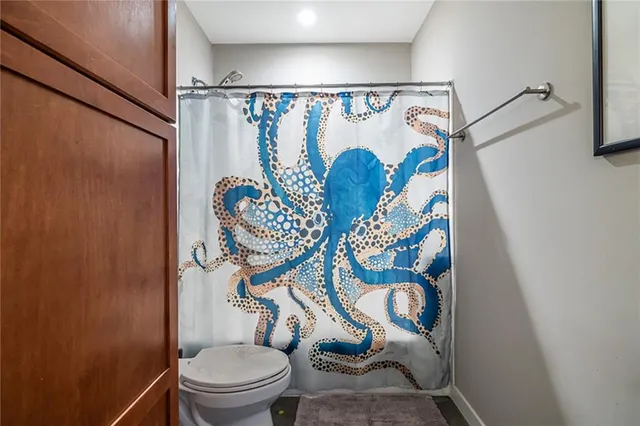 a bathroom with a toilet sink and shower curtain