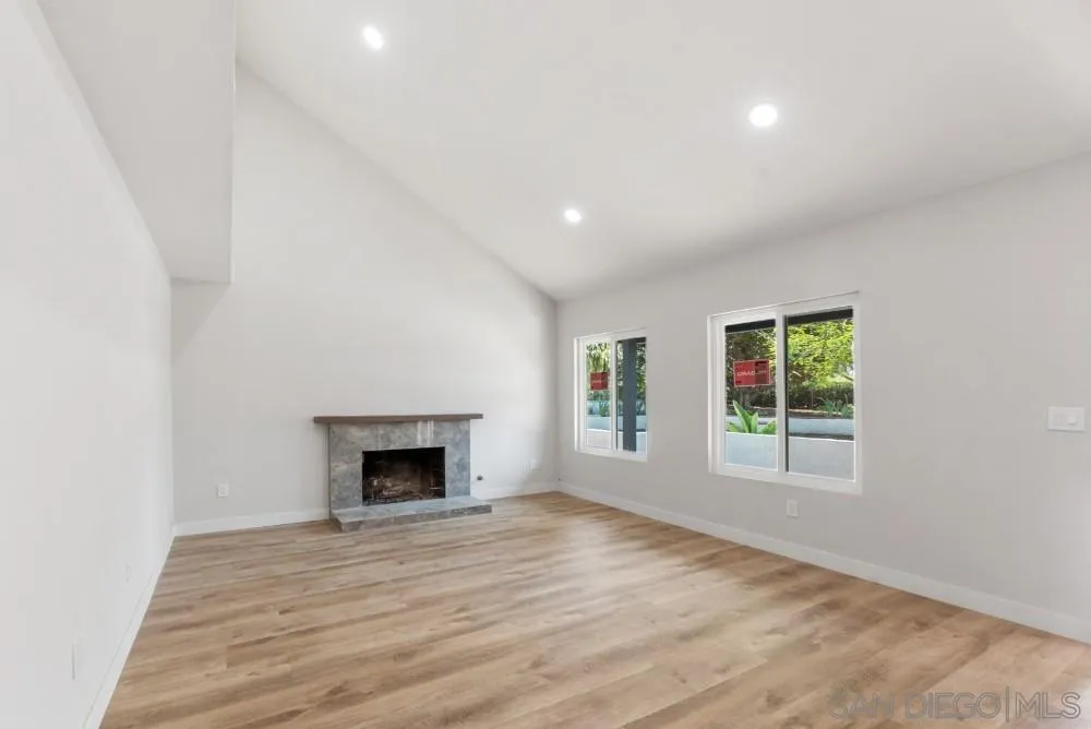 13765 Celestial Road Poway, CA 92064 - Photo 11 of 59 an empty room with wooden floor fireplace and windows