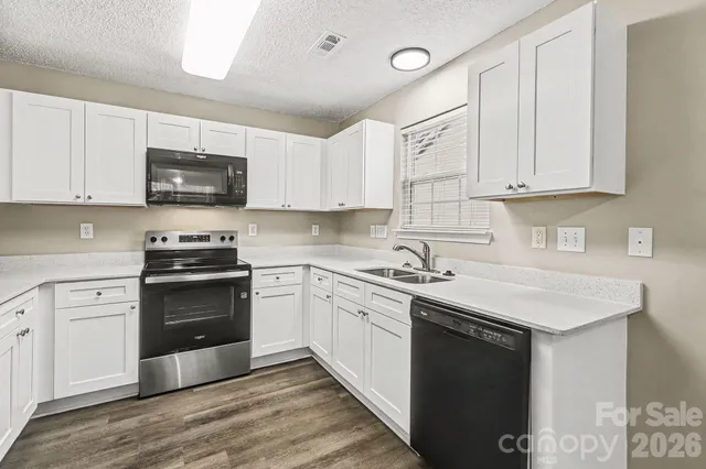 a kitchen with stainless steel appliances granite countertop a stove a sink and a microwave