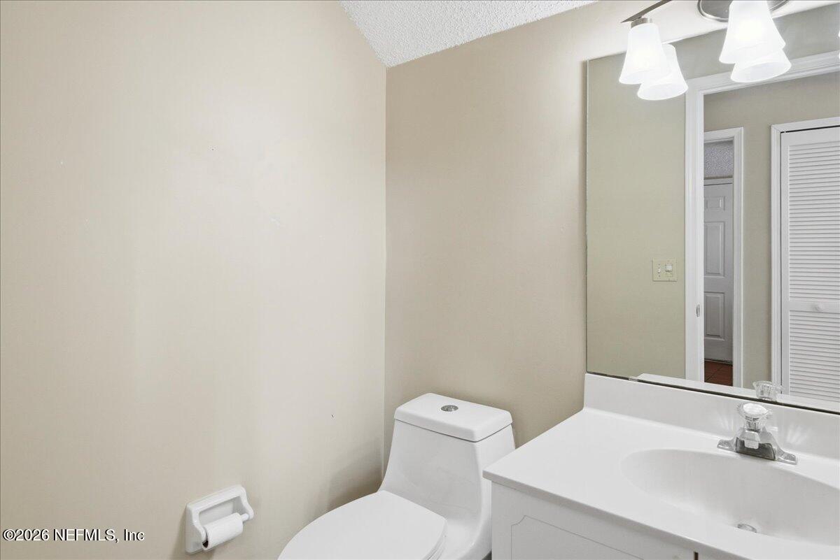 13075 Seedling Way Jacksonville, FL 32246 - Photo 21 of 48 a bathroom with a toilet a sink and mirror