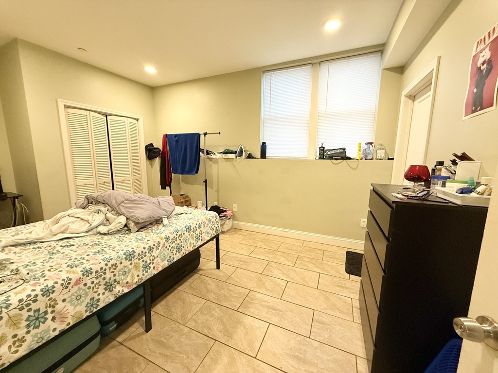 299 Dudley Street, Unit 1 Boston, MA 02119 - Photo 8 of 10 a bedroom with a bed and a dresser in it