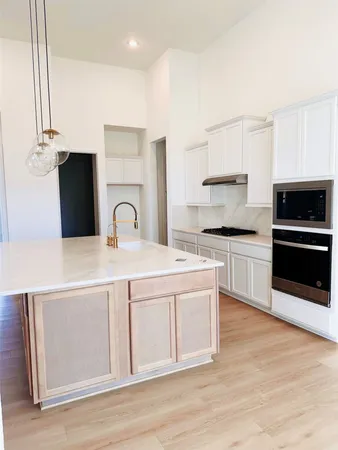 a kitchen with stainless steel appliances a stove top oven and cabinets