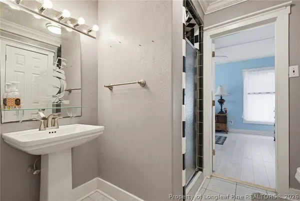 a bathroom with a sink a mirror a vanity and shower
