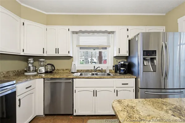a kitchen with stainless steel appliances granite countertop a stove a sink and a refrigerator