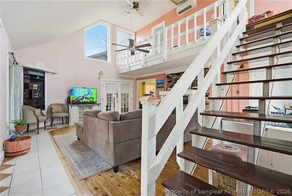 a living room with couches and a dining table with wooden floor