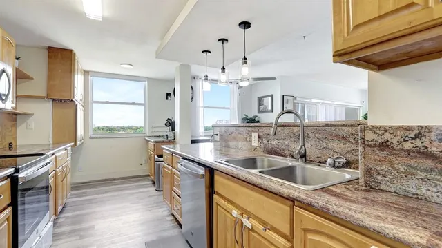 a kitchen with stainless steel appliances granite countertop a stove and a sink