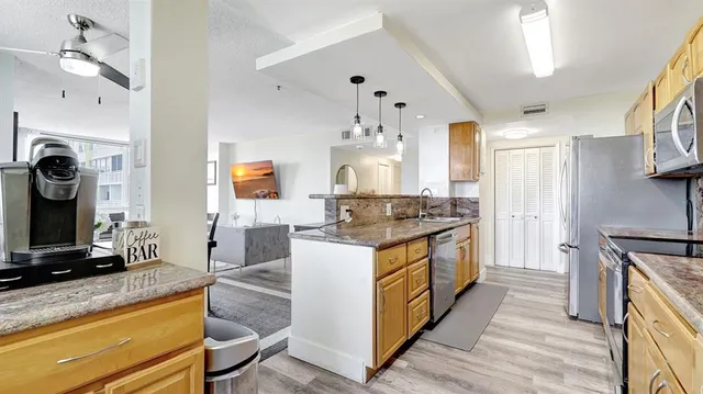 a kitchen with stainless steel appliances granite countertop a stove a sink and a refrigerator