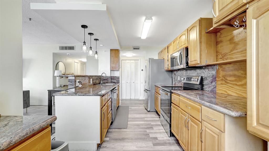 4400 Hillcrest Drive, Unit 719C Hollywood, FL 33021 - Photo 16 of 39 a kitchen with stainless steel appliances granite countertop a stove a sink and a refrigerator