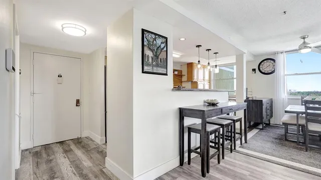 a kitchen with granite countertop a table chairs microwave and cabinets