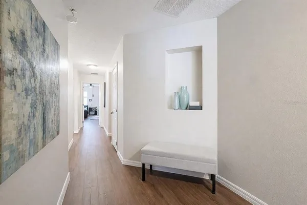 a hallway with a wooden floor and a chair