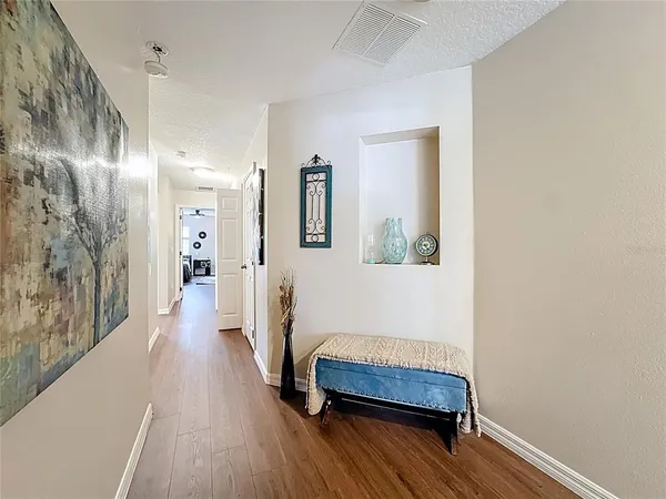 a hallway with a mirror and a wooden floor
