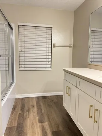 a view of a kitchen with wooden floor and a window