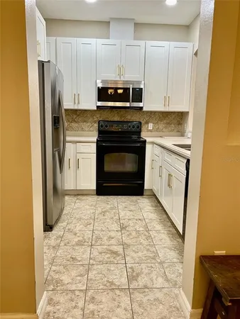 a kitchen with stainless steel appliances granite countertop a stove a refrigerator and a cabinets