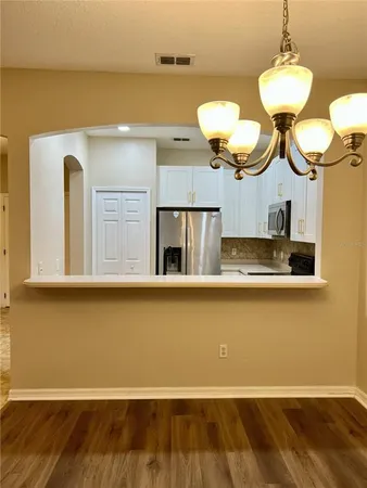 a kitchen with a cabinets and chandelier
