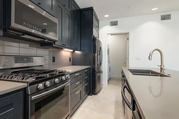 a kitchen with stainless steel appliances granite countertop a stove and a refrigerator