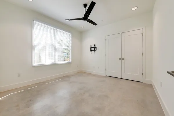 en empty room with windows and chandelier