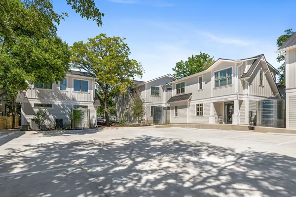 a white house that has a tree in front of it