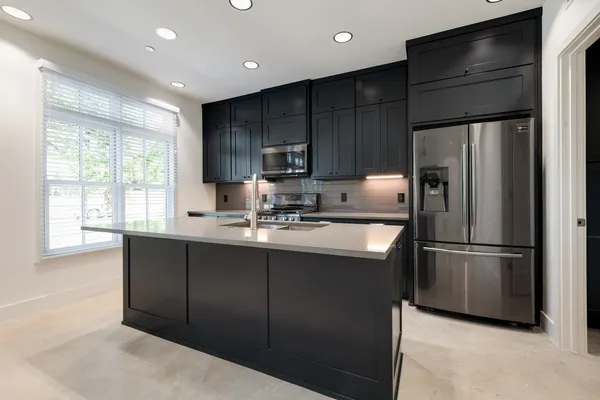 a kitchen with kitchen island granite countertop appliances cabinets and a sink