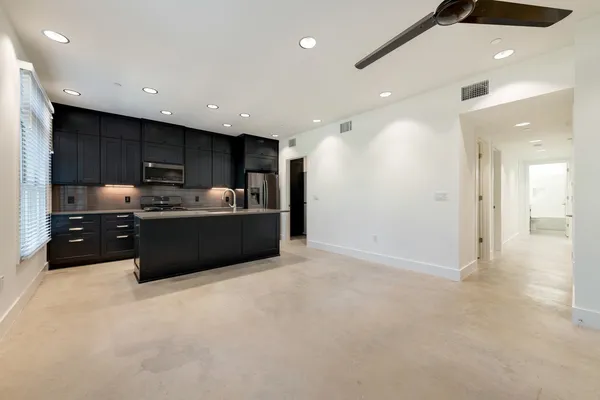 a kitchen with kitchen island a sink stainless steel appliances and cabinets