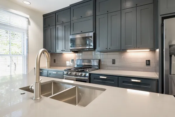 a kitchen with granite countertop a stove a sink and a granite counter tops