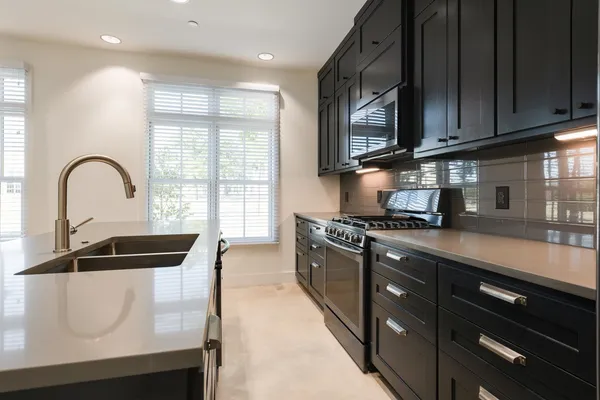 a kitchen with stainless steel appliances granite countertop a stove a sink and a microwave