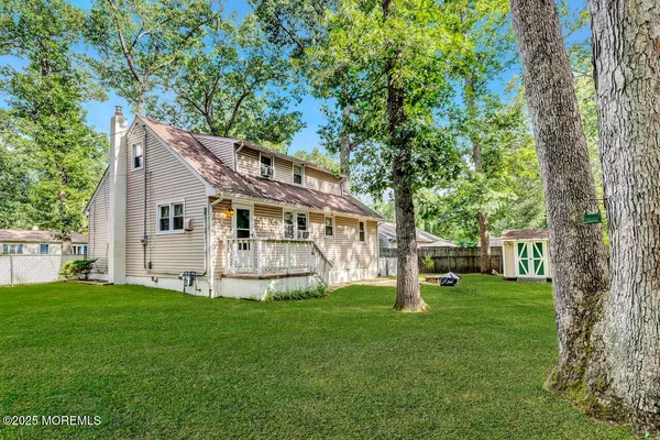 a view of a house with backyard and a tree