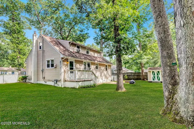 a view of a house with backyard and a tree
