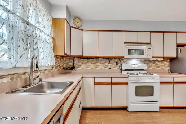 a kitchen with granite countertop white cabinets and white appliances