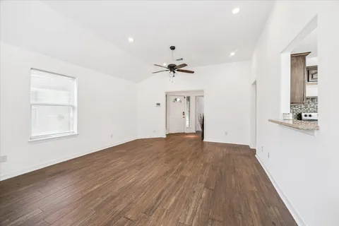 a large kitchen with granite countertop a sink and cabinets