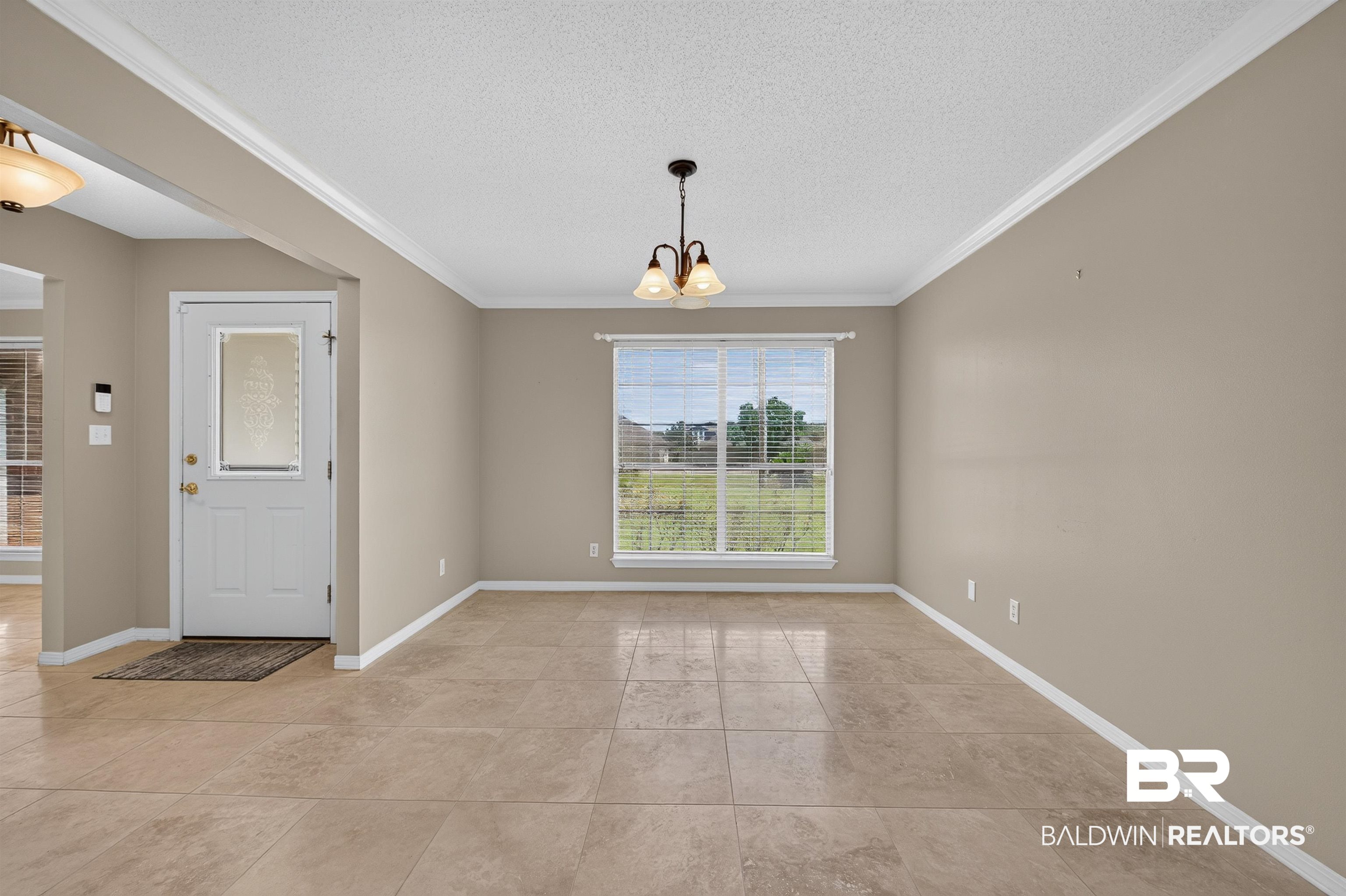 22685 County Road 12 Foley, AL 36535 - Photo 23 of 89 Expansive room featuring large format tile flooring, crown molding, and a chandelier light fixture