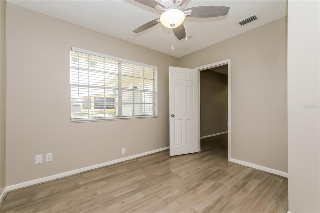 12345 Mayberry Road Spring Hill, FL 34609 - Photo 11 of 16 an empty room with wooden floor and windows