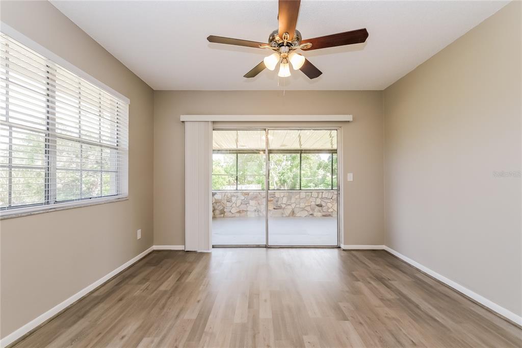 12345 Mayberry Road Spring Hill, FL 34609 - Photo 2 of 16 an empty room with wooden floor fan and windows