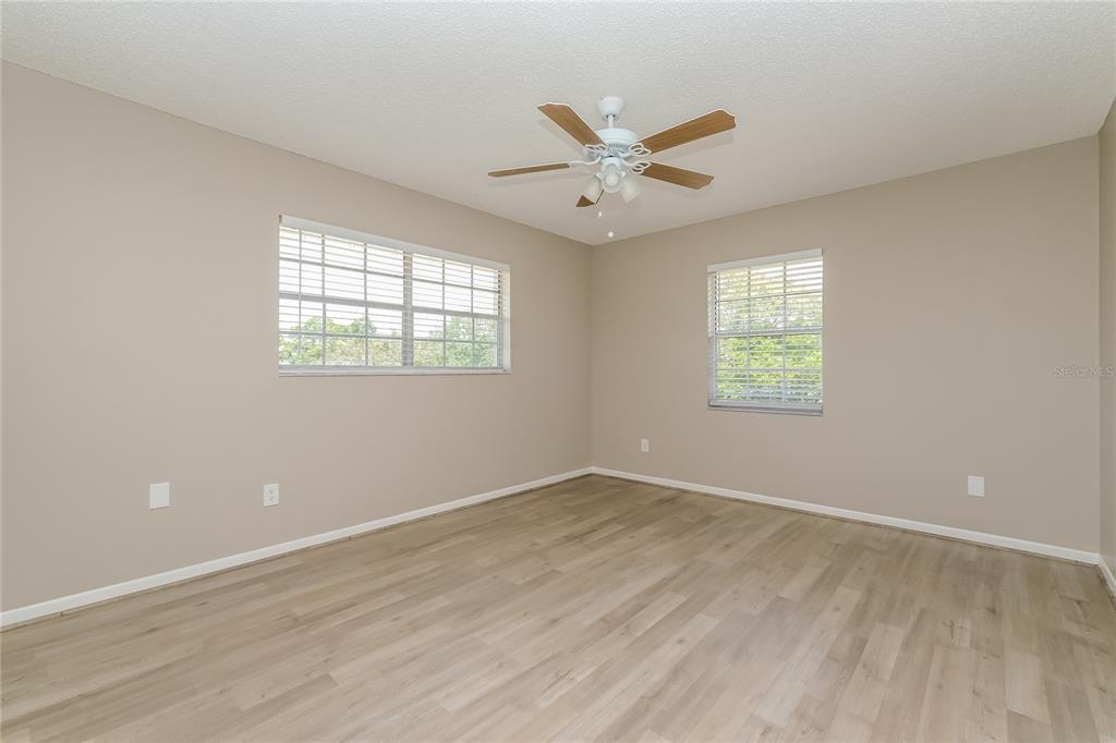 12345 Mayberry Road Spring Hill, FL 34609 - Photo 8 of 16 a view of an empty room with a window and wooden floor