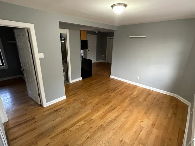 an empty room with wooden floor and entrance