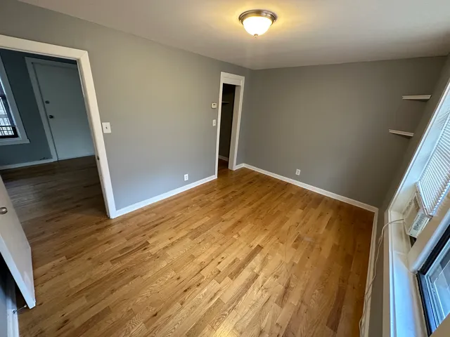 a view of empty room with wooden floor