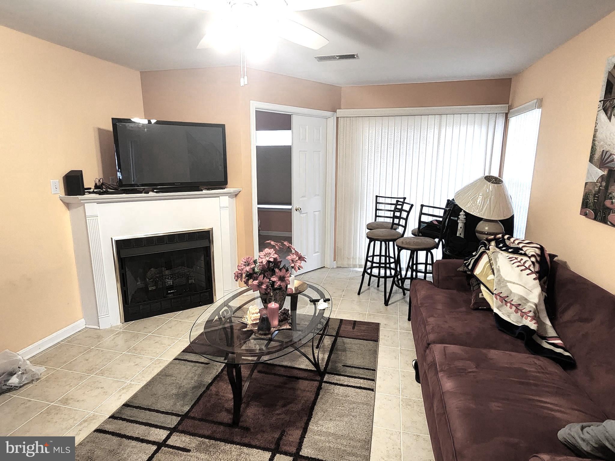 11427 Manklin Creek Road, Unit 7 Ocean Pines, MD 21811 - Photo 5 of 17 a living room with furniture and a fireplace