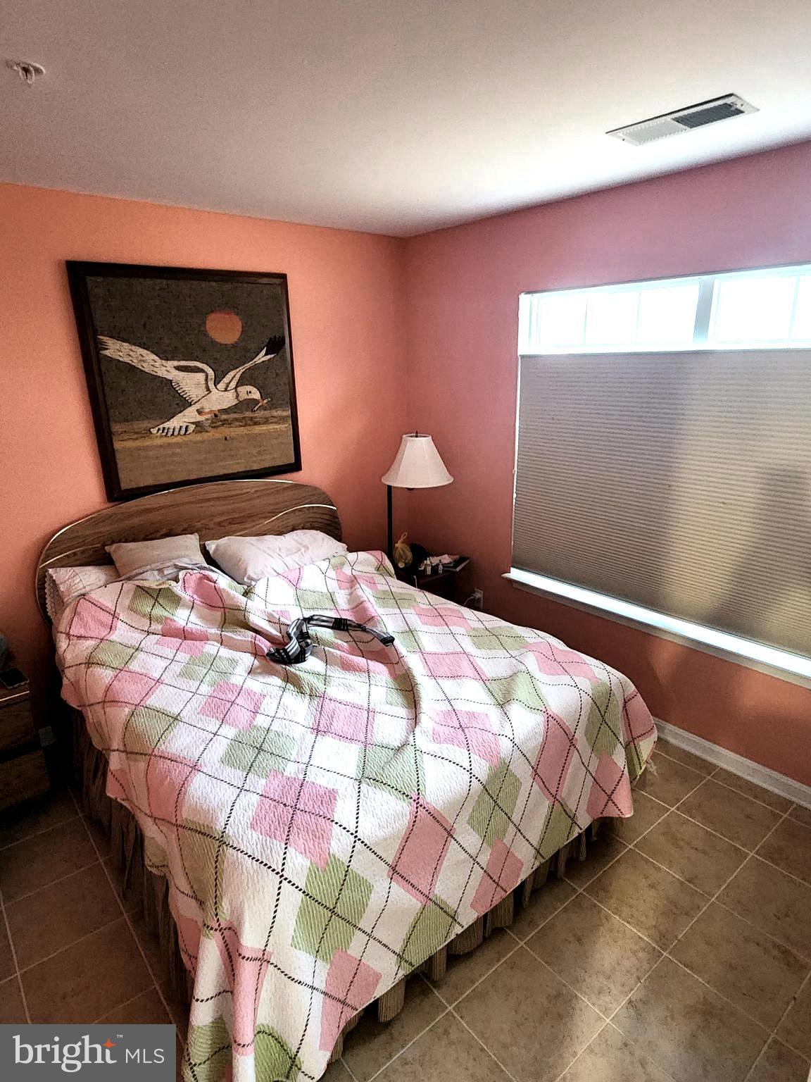 11427 Manklin Creek Road, Unit 7 Ocean Pines, MD 21811 - Photo 6 of 17 a bedroom with a bed and a painting on the wall