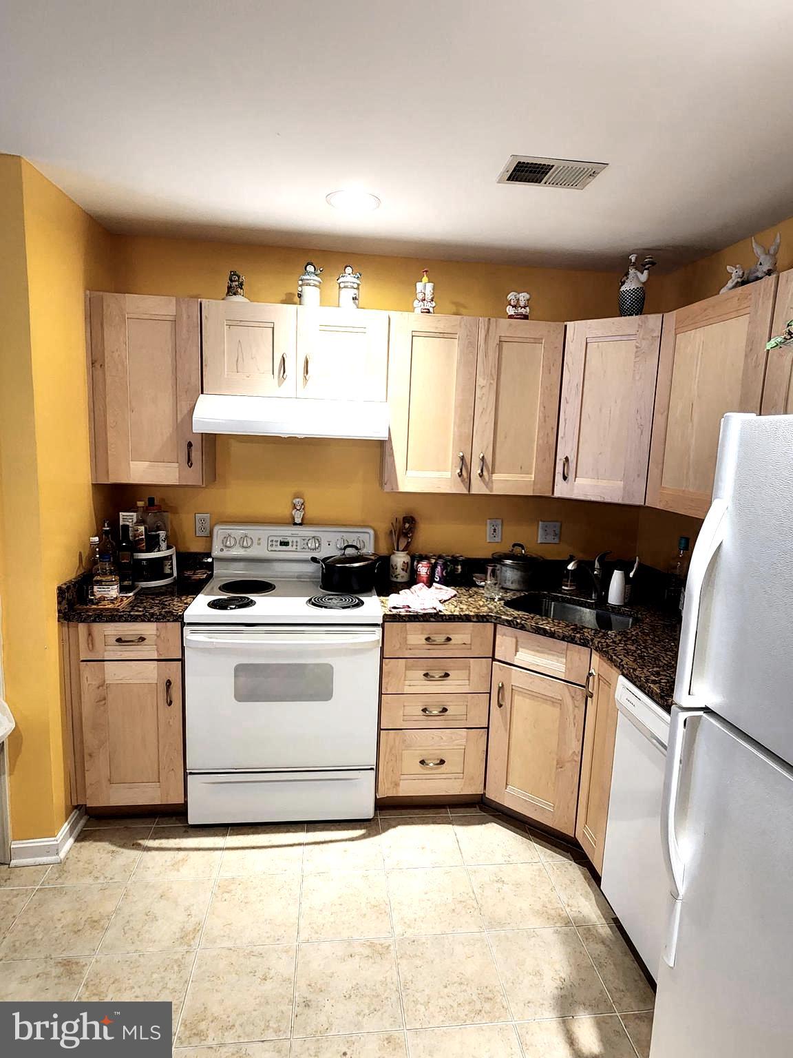 11427 Manklin Creek Road, Unit 7 Ocean Pines, MD 21811 - Photo 7 of 17 a kitchen with a stove a sink and a refrigerator